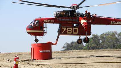 A Sikorsky S-64 Skycrane drafts Phos-Chek at heliport above Monrovia County Park for drops on the Station Fire